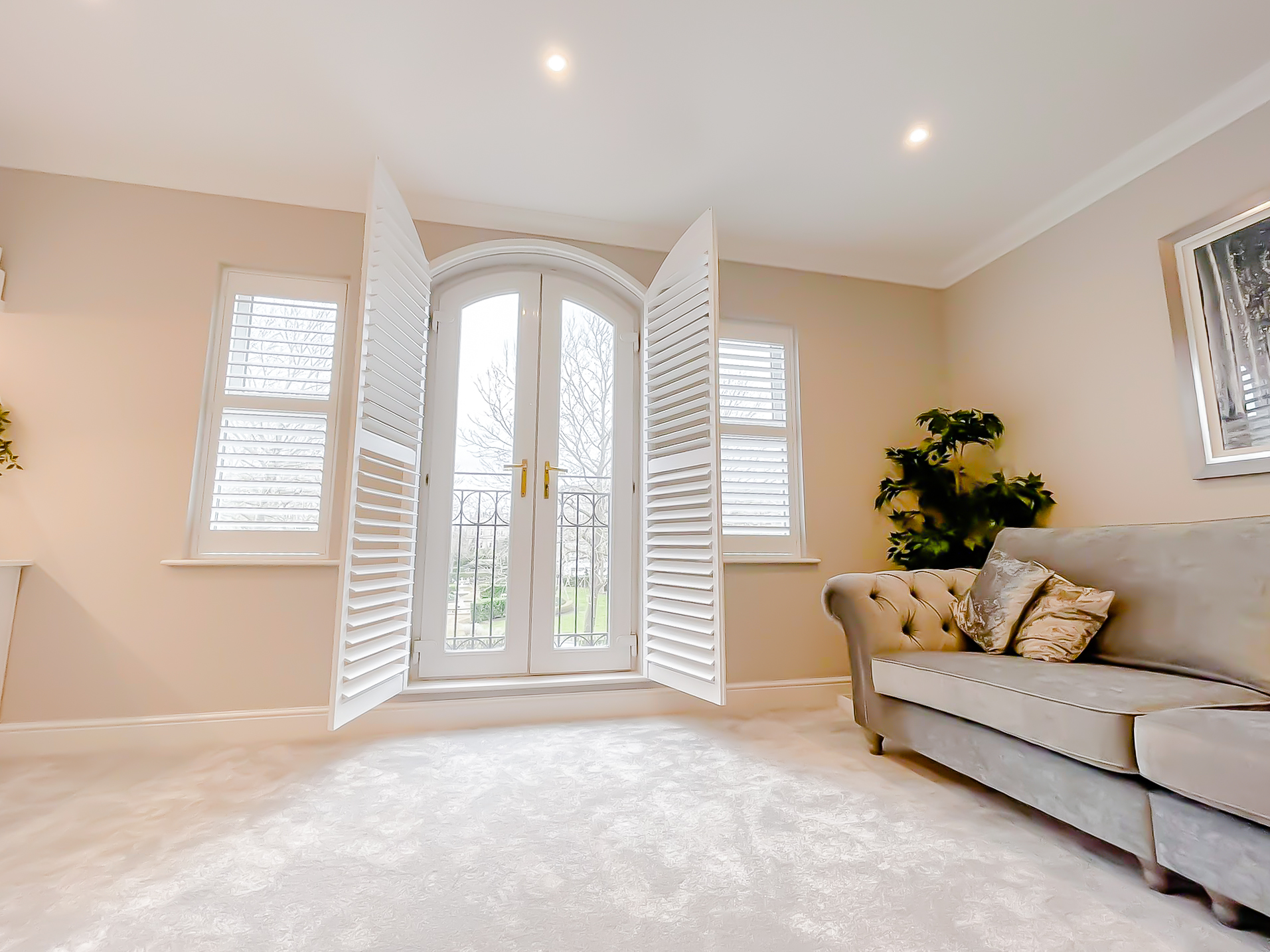 Full-height shutters opened back from arched French doors