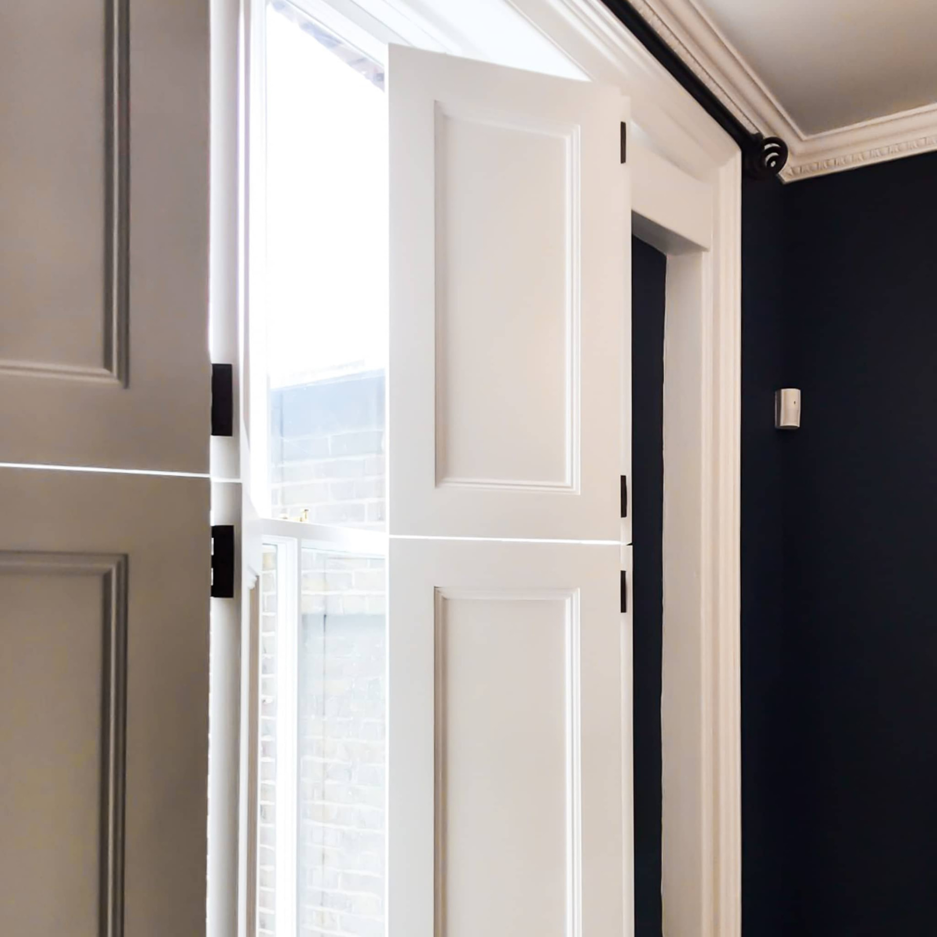 Solid panel shutters in a period hallway with dark walls